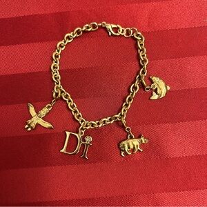 Diamonds International gold tone charm bracelet and 3 charms NWOT.
